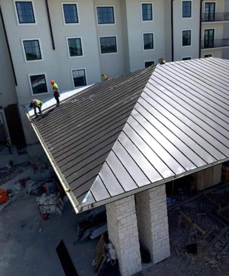 Crew installing standing seam metal roof panels on a commercial project in Laguna Woods